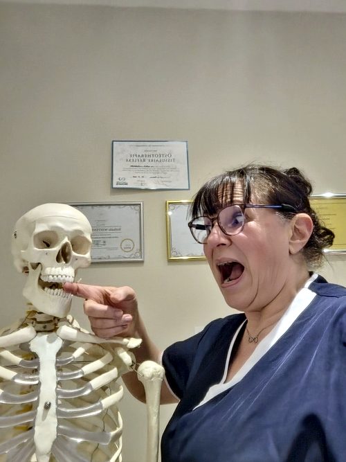 Nathalie fait mine d'être surprise en touchant la mâchoire d'Ernest, le squelette